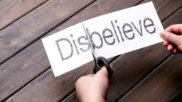 woman's beautiful hands cut paper by scissors on pattern wood plank